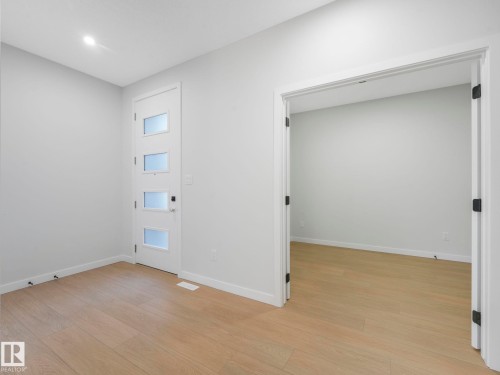 Contemporary entry area featuring a white door with frosted glass panels and sleek black hardware - 1717 Crossbill Loop, Edmonton, AB - Indoor Photo Showing Other Room