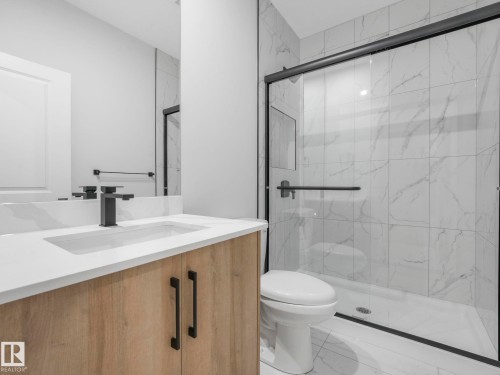 Contemporary bathroom featuring a light wood-finish vanity with a white countertop and integrated sink - 1717 Crossbill Loop, Edmonton, AB - Indoor Photo Showing Bathroom