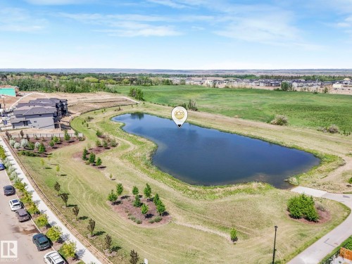 Aerial perspective showcasing a large retention pond surrounded by green spaces - 1717 Crossbill Loop, Edmonton, AB - Outdoor With View
