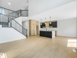 Open-concept living space with light wood-finish flooring - 