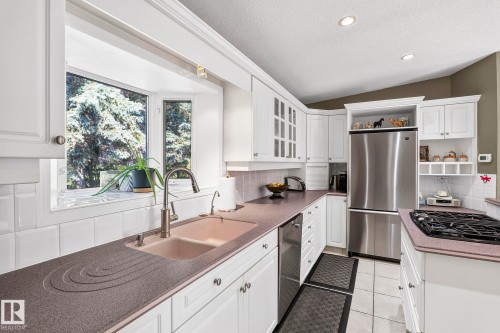 Kitchen featuring white cabinetry, a built-in stainless steel refrigerator, and a gas cooktop - 860 41 Avenue, Edmonton, AB 