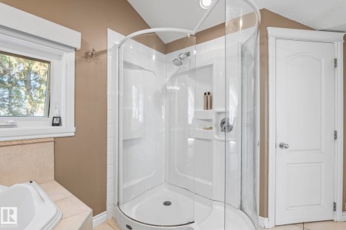 Corner shower enclosure featuring clear glass panels and an integrated shower head - 860 41 Avenue, Edmonton, AB 