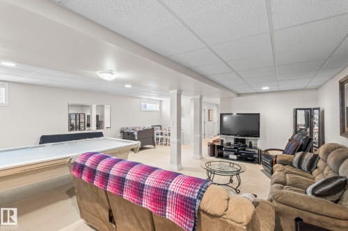 Finished basement with carpet flooring, recessed lighting, and drop ceiling panels - 860 41 Avenue, Edmonton, AB 