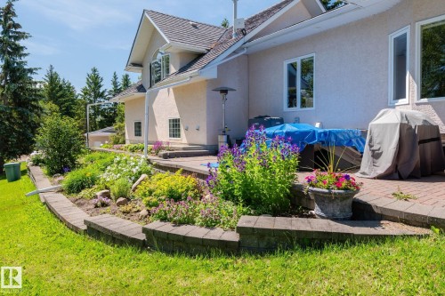Exterior featuring a multi-tiered patio with paver stones, stucco siding, and a gabled roof - 860 41 Avenue, Edmonton, AB 
