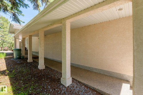 Covered porch with stippled stucco exterior and exposed aggregate concrete flooring - 860 41 Avenue, Edmonton, AB 