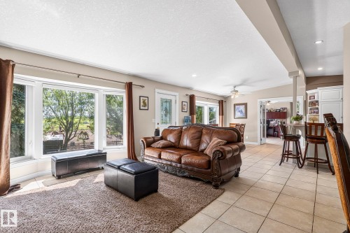 Spacious living area featuring large bay windows, recessed lighting, and tile flooring - 860 41 Avenue, Edmonton, AB 