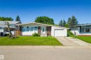 Ranch-style exterior featuring white siding, brick accents, and a front-facing garage - 14916 114A Street, Edmonton, AB 