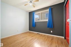 Room featuring wood-finish flooring, a ceiling fan with integrated lighting, and a window with a sill - 