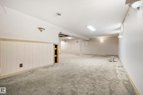 Spacious room featuring carpeting, white paneling, and ample overhead lighting - 14916 114A Street, Edmonton, AB 
