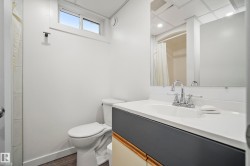 Modern bathroom featuring a vanity with a white countertop, chrome faucet, and integrated sink - 