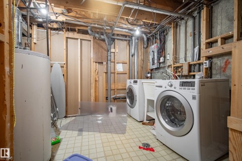 Utility area with exposed concrete walls, wood framing, and a water heater - 14916 114A Street, Edmonton, AB 