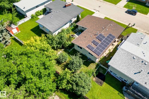 Residential property featuring solar panels, a brown shingle roof, and a beige exterior - 14916 114A Street, Edmonton, AB 