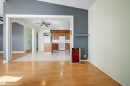 Open-concept living area featuring wood-finish flooring extending into the hallway - 14916 114A Street, Edmonton, AB 