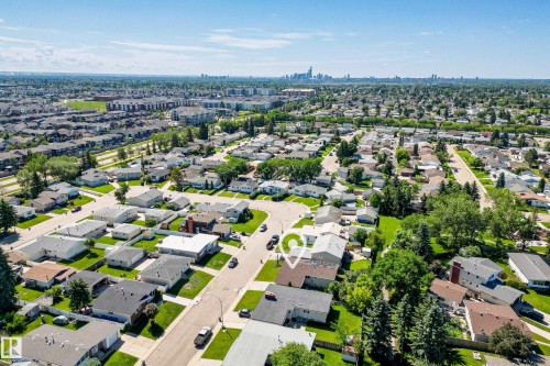 Aerial view showcasing a residential neighborhood with a distant cityscape on the horizon - 14916 114A Street, Edmonton, AB 