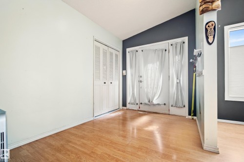 Wood-finish flooring throughout, featuring a vaulted ceiling and a double-door entry - 14916 114A Street, Edmonton, AB 