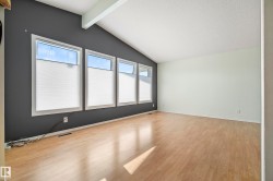 Spacious interior featuring wood-finish flooring and a vaulted ceiling with exposed beam - 