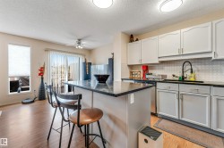 Kitchen featuring light gray cabinetry, dark countertops, and a white hexagonal tile backsplash - 