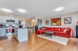 Open-concept living area featuring wood-finish flooring throughout - 