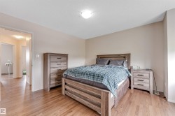 Wood-finish flooring throughout, complemented by light-toned wall paint and an overhead flush-mount light fixture - 