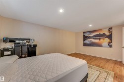 Spacious room featuring light-colored walls, wood-finish flooring, and recessed ceiling lighting - 