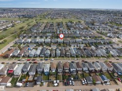 Aerial perspective of a residential community featuring rows of single-family homes with pitched roofs - 