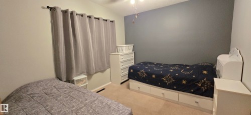 Carpeted room featuring a vaulted ceiling and a light fixture - 5304 49 Street, Two Hills, AB - Indoor Photo Showing Bedroom