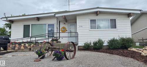 White horizontal siding exterior with a gravel driveway - 5304 49 Street, Two Hills, AB - Outdoor With Exterior