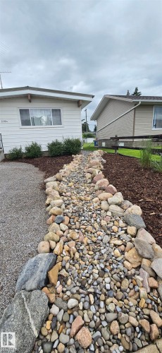 Rock-lined dry creek bed featuring natural stone and various sized pebbles - 5304 49 Street, Two Hills, AB - Outdoor