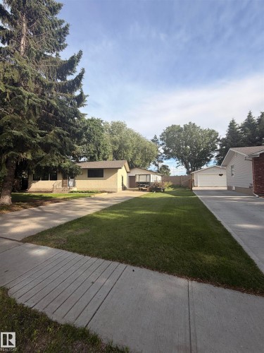 Single-story residence featuring a neutral-toned exterior, concrete driveway, attached garage, and mature landscaping - 8 Savoy Place, St. Albert, AB 