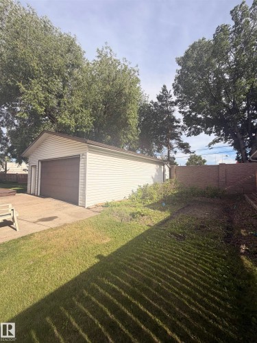 Detached garage with white vinyl siding and a brown overhead door - 8 Savoy Place, St. Albert, AB 