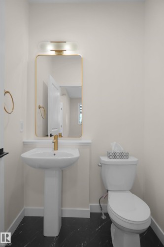 Pedestal sink with a gold-tone faucet set against light-toned walls - 8523 Mayday Run, Edmonton, AB 