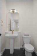 Pedestal sink with a gold-tone faucet set against light-toned walls - 