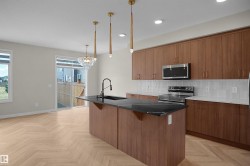 Open-concept kitchen and dining area featuring wood-finish herringbone flooring - 