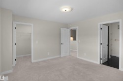 Spacious room featuring light-toned carpeting, neutral wall finishes, and white trim - 