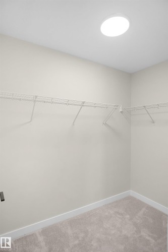 Walk-in closet featuring light-toned walls, white wire shelving, recessed ceiling lighting, and plush carpet flooring - 8523 Mayday Run, Edmonton, AB 