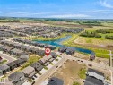 Aerial perspective highlighting a residential community with a central water feature and surrounding green spaces - 8523 Mayday Run, Edmonton, AB 
