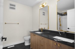 Dual vanity with wood-finish cabinetry and gold-tone hardware - 
