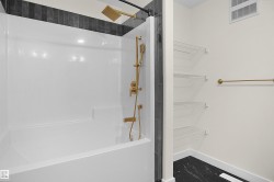 Shower and tub combination featuring a gold-toned rain shower head and handheld sprayer - 