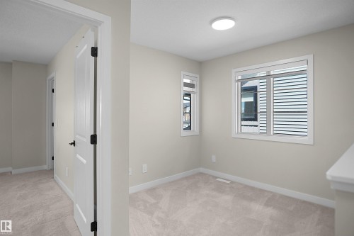 Carpeted room with neutral wall tones and white trim - 8523 Mayday Run, Edmonton, AB 