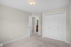 Interior room featuring light-colored walls, neutral carpet flooring, and white baseboards - 