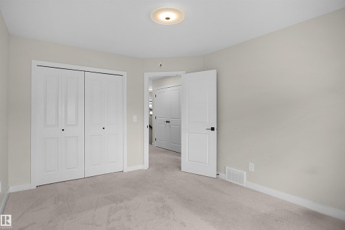 Carpeted room with light-toned walls, white trim, and a flush mount ceiling light fixture - 8523 Mayday Run, Edmonton, AB 