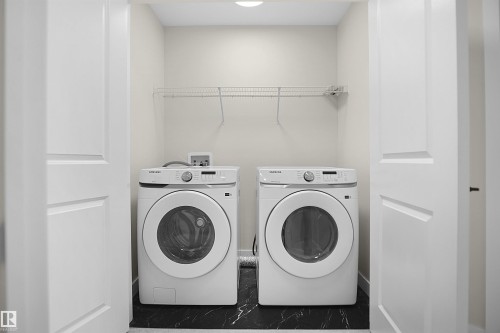 Dedicated laundry area featuring a front-loading washer and dryer set - 8523 Mayday Run, Edmonton, AB 