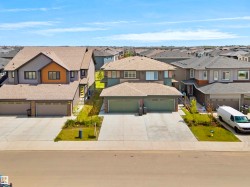 Contemporary residential property featuring a multi-tone facade with dark siding, light stucco, and a striking orange accent panel - 