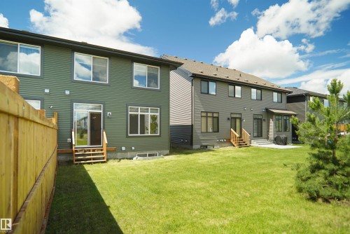 Expansive green lawn with a newly constructed wooden fence - 8523 Mayday Run, Edmonton, AB 