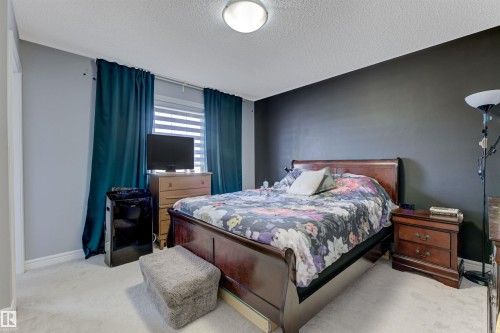 Bedroom featuring light gray walls, an accent wall, window blinds, and light-colored carpeting - 1311 30 Avenue, Edmonton, AB 