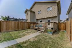 Rear exterior featuring a wood-plank deck with railing, a privacy fence, and a pergola structure - 