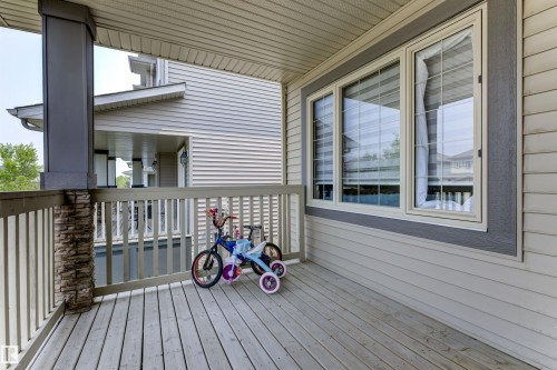 Covered porch featuring wood-finish decking and a railing system - 1311 30 Avenue, Edmonton, AB 