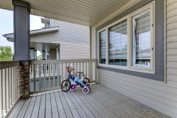 Covered porch featuring wood-finish decking and a railing system - 