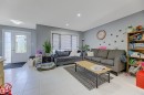 Bright living area featuring light-toned tile flooring, recessed lighting, and a front entry door with decorative glass inserts and a sidelight - 1311 30 Avenue, Edmonton, AB 