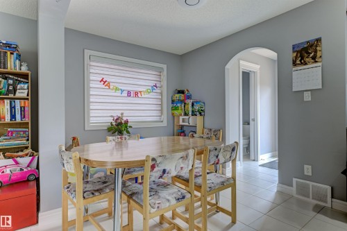 Dining area with neutral gray walls, white floor tiles, and a window with horizontal blinds - 1311 30 Avenue, Edmonton, AB 